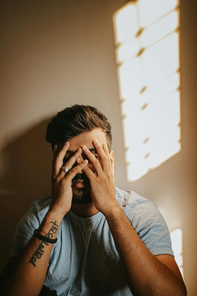 Young man covering his eyes with his hands phone screen with X on it : How to Effectively block porn on Twitter (X)